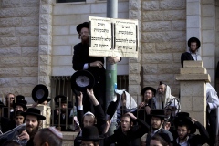 Ultra-Orthodox Jewish men gather around a sign that reads in Hebrew: Women are asked not to linger in this area outside a synagogue in Beit Shemesh on Monday.